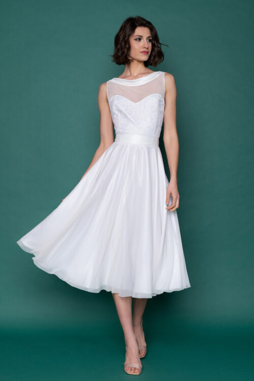 Ιβουάρ κλος vintage φόρεμα σε μεσάτη γραμμή, με λαιμουδιά χαμόγελο και σατέν τελείωμα που καταλήγει σε τιράντες πίσω. Η διαφάνεια στο μπούστο σε σχήμα καρδιά, η τούλινη φούστα και το δαντελένιο κορσάζ, δημιουργούν το απόλυτο vintage νυφικό look. 