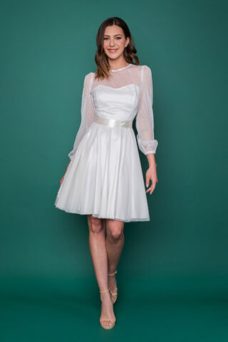 Εντυπωσιακό λευκό μεσάτο φόρεμα από πουά τούλι, με μακριά φουντωτά μανίκια και λαιμόκοψη σε σχήμα καρδιάς για το απόλυτο vintage νυφικό look. 