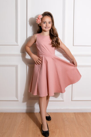 50s style ροζ πουά παιδικό φόρεμα, με κουμπάκια στον ώμο, λαιμουδιά χαμόγελο, ζώνη στη μέση και κλος φούστα με τσέπες.