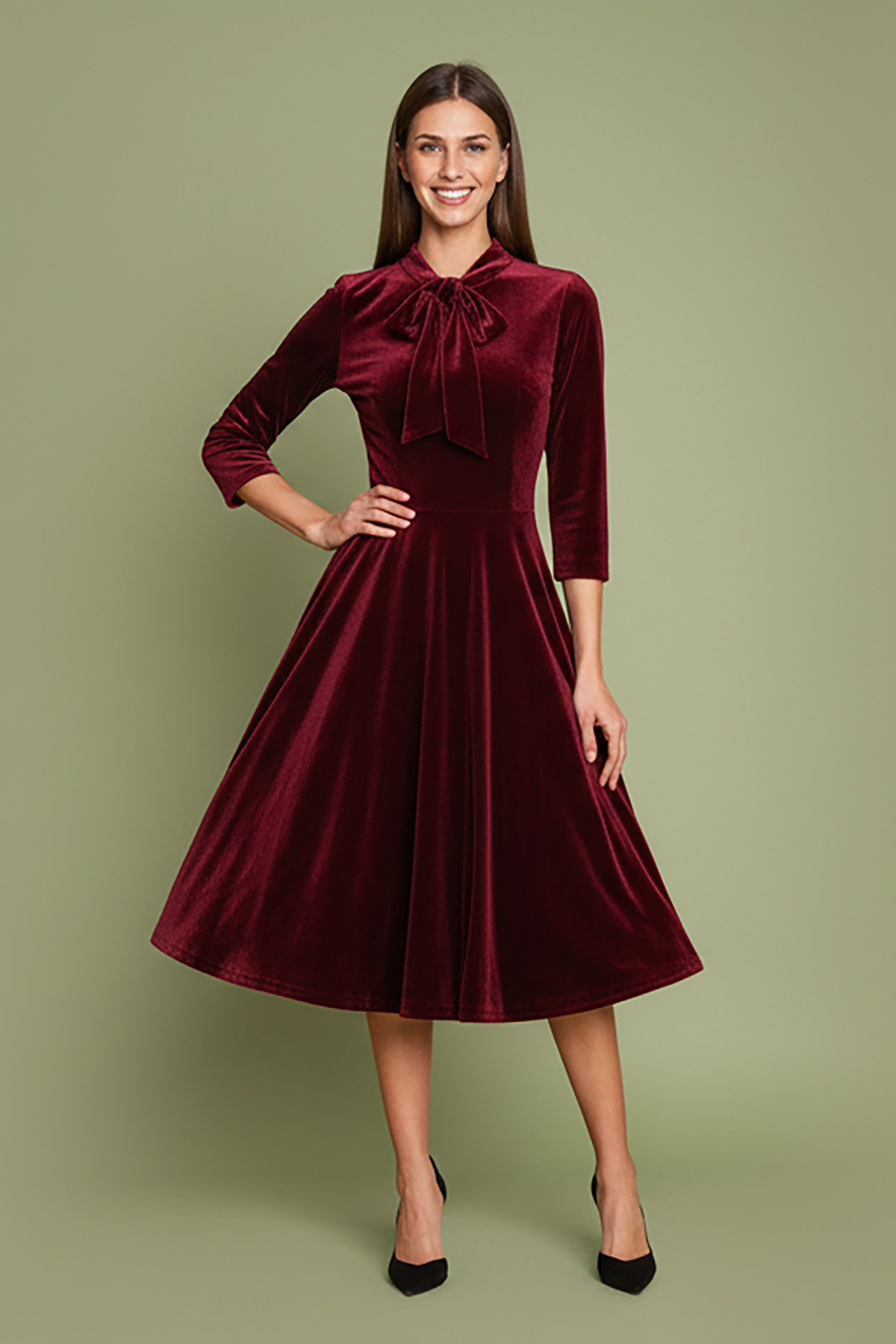 mpornto-veloudo-3 Μπορντό φόρεμα, εμπνευσμένο από τη λάμψη της δεκαετίας του 1950, από πολυτελές απαλό βελούδο, με κολακευτική λαιμόκοψη V που τονίζεται από έναν γοητευτικό φιόγκο από ύφασμα που δένει μπροστά. Οι ώμοι με την ελαφριά σούρα και τα 3/4 μανίκια προσθέτουν μια vintage πινελιά, ενώ η σταθερή ζώνη αγκαλιάζει τη σιλουέτα για ένα θηλυκό σχήμα. Σχεδιασμένο με κρυφές τσέπες με πλαϊνές ραφές και φούστα σε κλος γραμμή που κινείται με χάρη σε κάθε βήμα. Ιδανικό για επίσημες περιστάσεις ή απλώς για να αγκαλιάσει το κλασικό στυλ με μια μοντέρνα πινελιά.