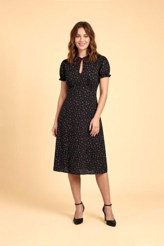 40s vintage φόρεμα, με απαράμιλλη σοφιστικέ αισθητική, που ξεχωρίζει για τον πανέμορφο κυματιστό γιακά σε χρωματική αντίθεση και το ιδιαίτερο άνοιγμα στο ντεκολτέ που κλείνει με κουμπί. Η κλασική fit & flare γραμμή του αγκαλιάζει τη σιλουέτα, ενώ τα κοντά, ελαστικά μανίκια με λεπτομέρειες από βολάν προσθέτουν μια επιπλέον δόση ρομαντισμού. Κατασκευασμένο από 100% φυσικό βαμβάκι, είναι το ιδανικό φόρεμα για να παραμείνετε κομψή και δροσερή καθ' όλη τη διάρκεια του καλοκαιριού.