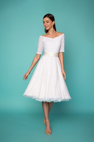 Δαντελένιο midi φόρεμα σε μεσάτη γραμμή, από υπέροχη λευκή δαντέλα και μήκος μέχρι το γόνατο, με κοντά ελαστικά μανίκια και λαιμουδιά που σχηματίζει καρδιά, είναι το πιο chic φόρεμα για να συνοδεύσει μια επίσημη εμφάνισή σας. 