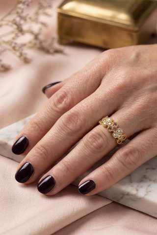 Ένα ντελικάτο δαχτυλίδι που αποπνέει ανοιξιάτικη φρεσκάδα και vintage γοητεία. Ο σχεδιασμός του θυμίζει ανθισμένα λουλούδια, στολισμένα με μια αρμονική παλέτα πολύχρωμων κρυστάλλων σε αποχρώσεις του ροζ, του γκρι-μπλε και του διάφανου. Κάθε κρύσταλλος περιβάλλεται από ένα περίτεχνο χρυσό πλαίσιο, προσφέροντας μια αίσθηση πολυτέλειας.