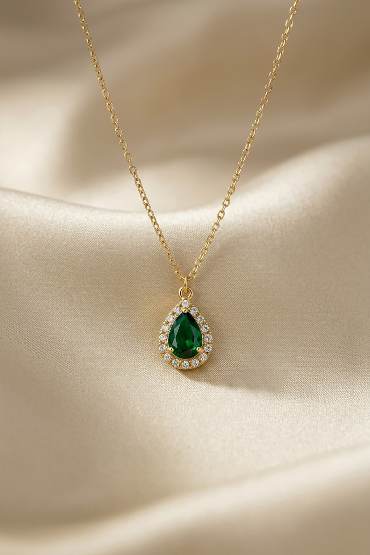 emerald-drop-kremasto-2 Ένα ντελικάτο κρεμαστό που θυμίζει πολύτιμο εύρημα από άλλη εποχή. Το κεντρικό στοιχείο σε σχήμα δακρύου διαθέτει έναν κρύσταλλο σε βαθύ σμαραγδί χρώμα, ο οποίος πλαισιώνεται από μια σειρά μικρότερων, διάφανων κρυστάλλων που ενισχύουν τη λάμψη του.