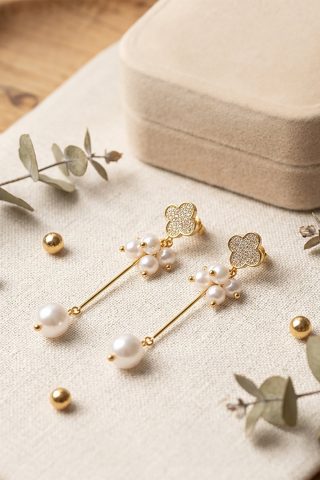 Αυτά τα εντυπωσιακά κρεμαστά σκουλαρίκια συνδυάζουν τη λάμψη των ζιργκόν, την απαλότητα των μαργαριταριών και τον συμβολισμό του τετράφυλλου τριφυλλιού σε ένα κομψό και μοντέρνο σχέδιο. Είναι το τέλειο αξεσουάρ για να αναβαθμίσετε κάθε σας εμφάνιση, από μια καθημερινή βόλτα μέχρι μια επίσημη έξοδο.