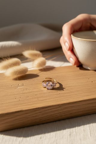 Ένα αριστοκρατικό δαχτυλίδι που μαγνητίζει τα βλέμματα με την καθαρότητα των κρυστάλλων του. Διαθέτει μια εντυπωσιακή κεντρική πέτρα, η οποία πλαισιώνεται από δύο μικρότερους, λαμπερούς κρυστάλλους στις πλευρές. Ο σχεδιασμός του θυμίζει πολύτιμα οικογενειακά κειμήλια, προσφέροντας μια αίσθηση πολυτέλειας που αναβαθμίζει κάθε επίσημη ή καθημερινή σας εμφάνιση.