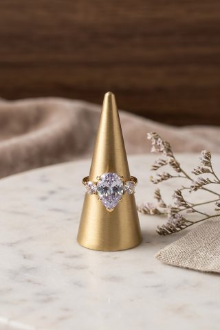 Εντυπωσιακό και τολμηρό, αυτό το δαχτυλίδι είναι η επιτομή της vintage-inspired κομψότητας, με μια μοναδική χρωματική σφραγίδα. Στο κέντρο του δεσπόζει ένας περίτεχνος κρύσταλλος, με τον κεντρικό σε σχήμα αχλαδιού (pear-shaped) σε λευκή απόχρωση. 