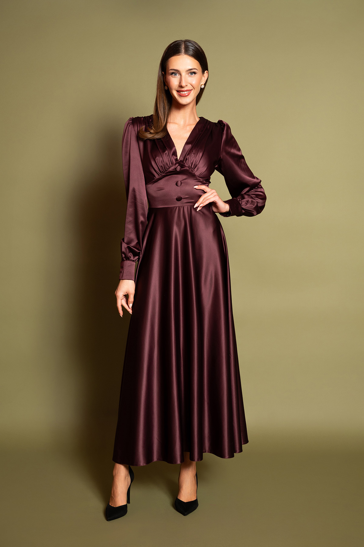 plum-saten-midi-forema-2 Ανακαλύψτε την απόλυτη πολυτέλεια με ένα plum σατέν μίντι φόρεμα. Διαθέτει θηλυκή V λαιμόκοψη, σούρες στο στήθος, μακριά μανίκια και διακοσμητικά ντυμένα κουμπιά στη μέση. Η αέρινη κλος φούστα χαρίζει κίνηση και διαχρονική ρετρό κομψότητα σε κάθε επίσημη εμφάνιση.