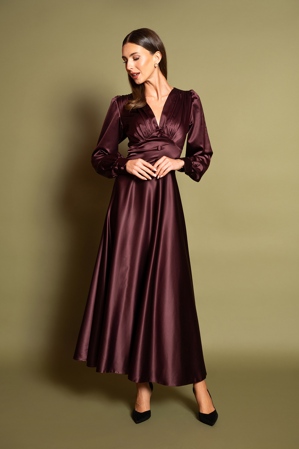 plum-saten-midi-forema-3 Ανακαλύψτε την απόλυτη πολυτέλεια με ένα plum σατέν μίντι φόρεμα. Διαθέτει θηλυκή V λαιμόκοψη, σούρες στο στήθος, μακριά μανίκια και διακοσμητικά ντυμένα κουμπιά στη μέση. Η αέρινη κλος φούστα χαρίζει κίνηση και διαχρονική ρετρό κομψότητα σε κάθε επίσημη εμφάνιση.