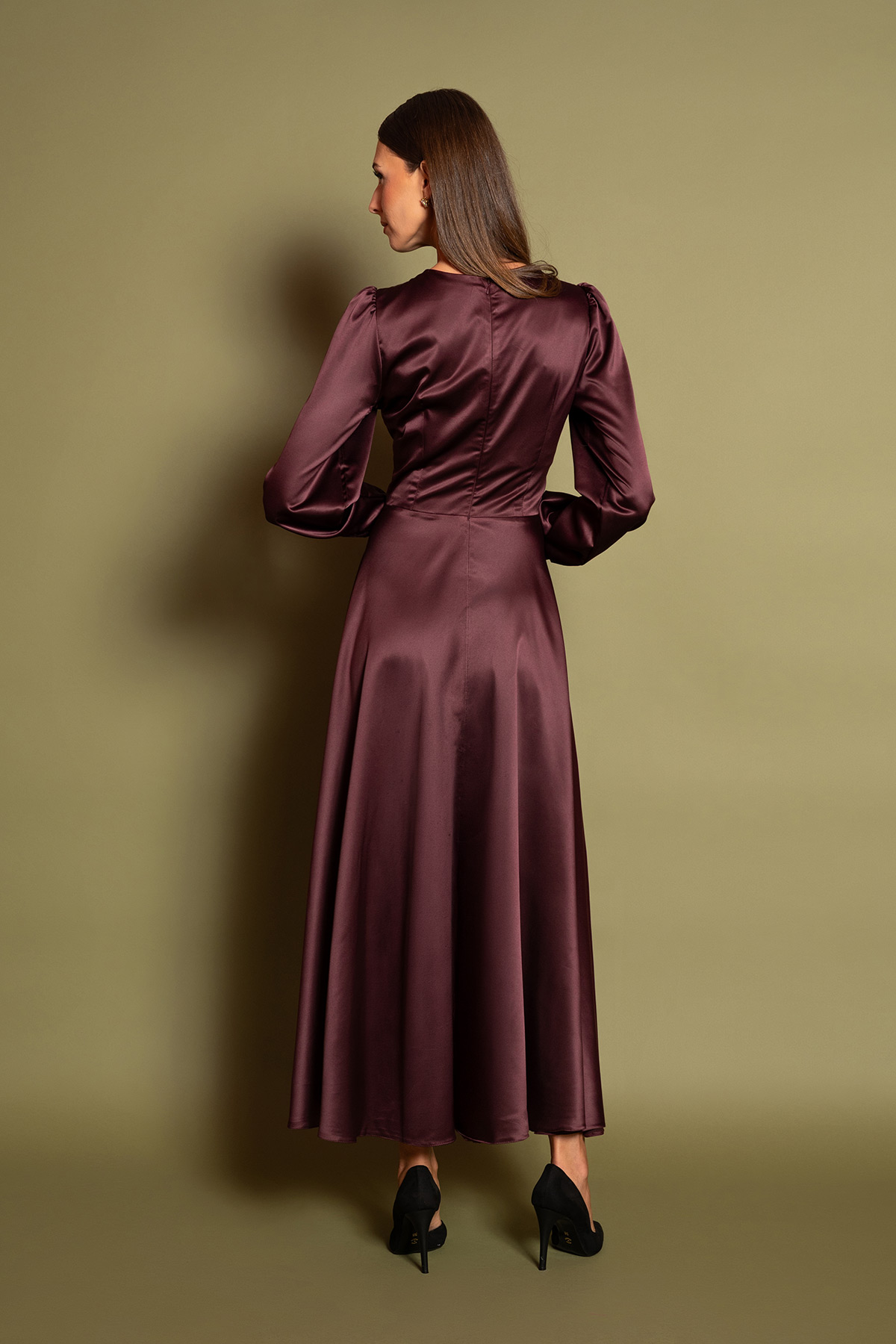 plum-saten-midi-forema-5 Ανακαλύψτε την απόλυτη πολυτέλεια με ένα plum σατέν μίντι φόρεμα. Διαθέτει θηλυκή V λαιμόκοψη, σούρες στο στήθος, μακριά μανίκια και διακοσμητικά ντυμένα κουμπιά στη μέση. Η αέρινη κλος φούστα χαρίζει κίνηση και διαχρονική ρετρό κομψότητα σε κάθε επίσημη εμφάνιση.